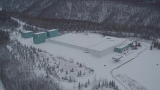 AK0001_1615 - 4K aerial stock footage flyby a snow covered warehouse building, Chugiak, Alaska