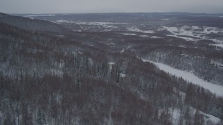 AK0001_1628 - 4K aerial stock footage approaching homes in snow covered, wooded hills, Chugiak, Alaska