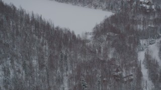 AK0001_1630 - 4K aerial stock footage flying away from kids playing hockey, homes in snow covered woods, Chugiak, Alaska