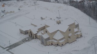 AK0001_1635 - 4K aerial stock footage orbiting a snow covered church in Eagle River, Alaska