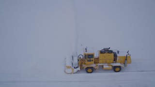 AK0001_1647 - 4K aerial stock footage flying by a snow plow clearing Merrill Field at twilight, Anchorage, Alaska