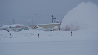 AK0001_1649 - 4K aerial stock footage airplanes at Merrill Field, reveal passing snow plow at twilight, Anchorage, Alaska