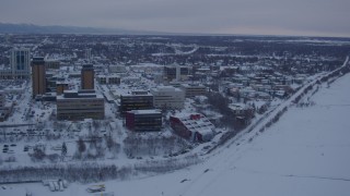 AK0001_1654 - 4K aerial stock footage snowy Downtown Anchorage, flying over shore of Cook Inlet at twilight, Alaska