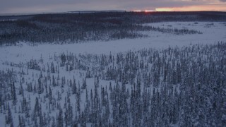 AK0001_1671 - 4K aerial stock footage flying low over frozen, snowy ground at twilight on Point MacKenzie, Alaska