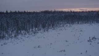 AK0001_1672 - 4K aerial stock footage flying low over frozen, snowy ground at sunset, Point MacKenzie, Alaska