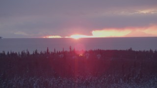 AK0001_1675 - 4K aerial stock footage the sun setting behind clouds, Point MacKenzie, Alaska in snow