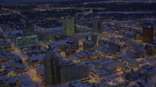 AK0001_1722 - 4K aerial stock footage orbiting snow covered Downtown Anchorage at night, Alaska