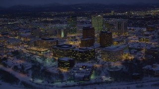 AK0001_1723 - 4K aerial stock footage orbiting snow covered Downtown Anchorage at night, Alaska
