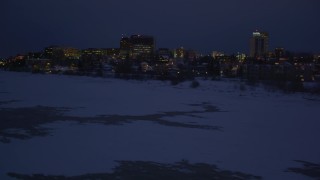 AK0001_1727 - 4K aerial stock footage flying along icy shore of Cook Inlet, snowy Downtown Anchorage, Alaska, night
