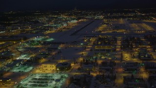 AK0001_1736 - 4K aerial stock footage flying toward snow covered Merrill Field at night, Anchorage, Alaska