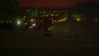 AK0001_1737 - 4K aerial stock footage a snow plow clearing snow at night, Anchorage, Alaska