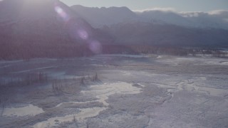 AK0001_1767 - 4K aerial stock footage panning across a river valley to snow-capped Chugach Mountains, Alaska