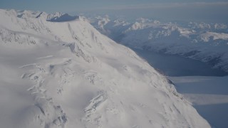 AK0001_1780 - 4K aerial stock footage rounding snowy slopes near Harriman Fjord, Chugach Mountains, Alaska