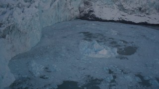 AK0001_1817 - 4K aerial stock footage pan from edge of snow covered glacier, to Harriman Fjord, revealing chunk of glacial ice, Alaska