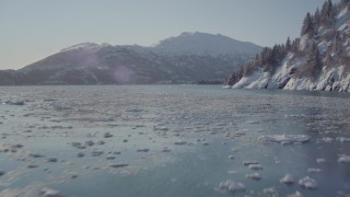 AK0001_1829 - 4K aerial stock footage flying low over surface of Harriman Fjord bordered by snowy mountains, Alaska
