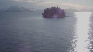 AK0001_1854 - 4K aerial stock footage approach a tiny, wooded island, with a view of Chugach Mountains, Port Wells, Alaska