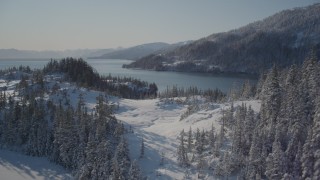 AK0001_1858 - 4K aerial stock footage flying over snowy and forested hills, Port Wells, Alaska