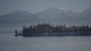 AK0001_1871 - 4K aerial stock footage the evergreen trees and snow covered Chugach Mountains across Port Wells, Alaska