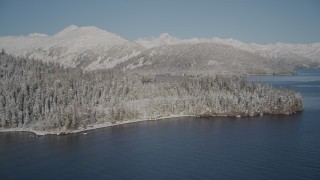 AK0001_1879 - 4K aerial stock footage descending toward Port Wells and the snowy, wooded shore, Alaska