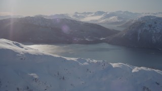 AK0001_1895 - 4K aerial stock footage flying over snow covered mountain toward Pigot Bay, Alaska
