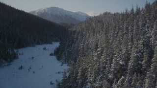 AK0001_1899 - 4K aerial stock footage flying between snow covered forested slopes, Port Wells, Alaska