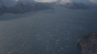 AK0001_1905 - 4K aerial stock footage windblown water of Passage Canal beside snowy shore, Alaska, tilt to Chugach Mountains
