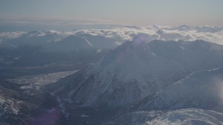 AK0001_1936 - 4K stock footage aerial video flying by a river valley surrounded by snowy Chugach Mountains, Alaska