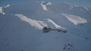AK0001_1966 - 4K aerial stock footage snow covered ski lodge and ski lift at summit of mountain, Girdwood, Alaska