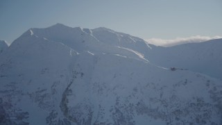 AK0001_1970 - 4K aerial stock footage flying away from a snow covered mountain peak, Girdwood, Alaska