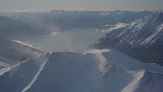 AK0001_1983 - 4K aerial stock footage snowy Kenai Mountains across Turnagain Arm of the Cook Inlet, Alaska