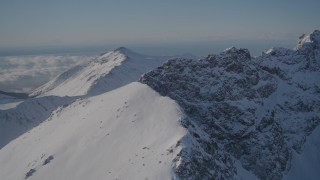 AK0001_1991 - 4K stock footage aerial video flying over a snow covered mountain ridge in the Chugach Mountains, Alaska