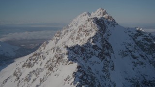 AK0001_1992 - 4K aerial stock footage flying toward the snowy summit of a peak in the Chugach Mountains, Alaska