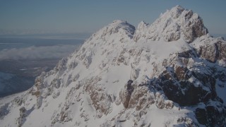 AK0001_1993 - 4K aerial stock footage flying over snowy summit of a peak in the Chugach Mountains, Alaska