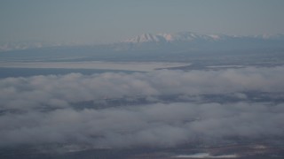 AK0001_2003 - 4K aerial stock footage snowy Mount Susitna near Point MacKenzie, clouds covering Anchorage, Alaska