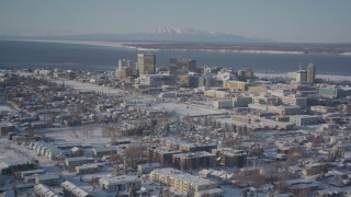 AK0001_2013 - 4K aerial stock footage flying over snowy residential buildings toward Downtown Anchorage, Alaska