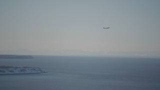 AK0001_2019 - 4K aerial stock footage a passenger jet soaring over the Cook Inlet, Anchorage, Alaska in snow