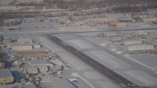 AK0001_2027 - 4K aerial stock footage a small airplane taking off from snow covered Merrill Field, Anchorage, Alaska