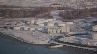 AK0001_2031 - 4K aerial stock footage flying away from a snow covered oil refinery in Anchorage, Alaska