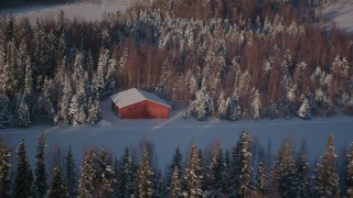AK0001_2035 - 4K aerial stock footage flying away from a small cabin on a snowy road in Point MacKenzie, Alaska