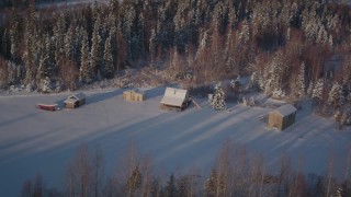 AK0001_2036 - 4K aerial stock footage fly by small cabins near snowy forest in Point MacKenzie, Alaska