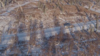 AK0001_2044 - 4K aerial stock footage flying toward a rural highway in Point MacKenzie, Alaska in snow