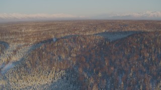 AK0001_2067 - 4K aerial stock footage flying over houses surrounded by snowy forest in Knik-Fairview at sunset, Alaska