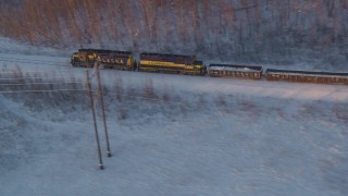AK0001_2078 - 4K aerial stock footage tracking a train running through snowy forest at sunset, Wasilla, Alaska