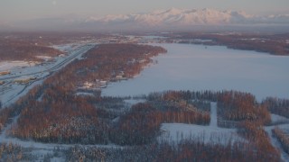 AK0001_2082 - 4K aerial stock footage Lucile Lake, moon over snowy Chugach Mountains, Wasilla, Alaska, sunset