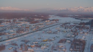 AK0001_2087 - 4K aerial stock footage Lucile Lake toward Wasilla Lake with snow on the ground at twilight, Alaska