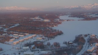 AK0001_2088 - 4K aerial stock footage flying over snow covered Wasilla near Wasilla Lake at sunset, Alaska