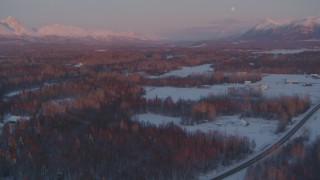 AK0001_2094 - 4K aerial stock footage fly over snow covered neighborhoods, reveal mountains, Palmer, Alaska, twilight