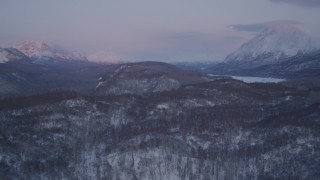 AK0001_2109 - 4K aerial stock footage snowy, wooded hills, Matanuska River Valley, Chugach Mountains, Alaska, sunset