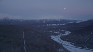 AK0001_2116 - 4K aerial stock footage moon over snowy Talkeetna Mountains, Matanuska River Valley, Alaska, twilight