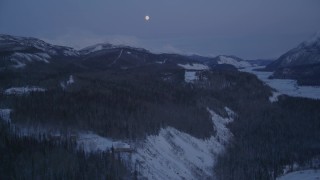 AK0001_2120 - 4K aerial stock footage reveal moon over snow covered Talkeetna Mountains at twilight, Sutton, Alaska